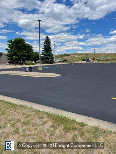 Image of a parking lot in Evergreen, CO with workers painting new parking stall lines.