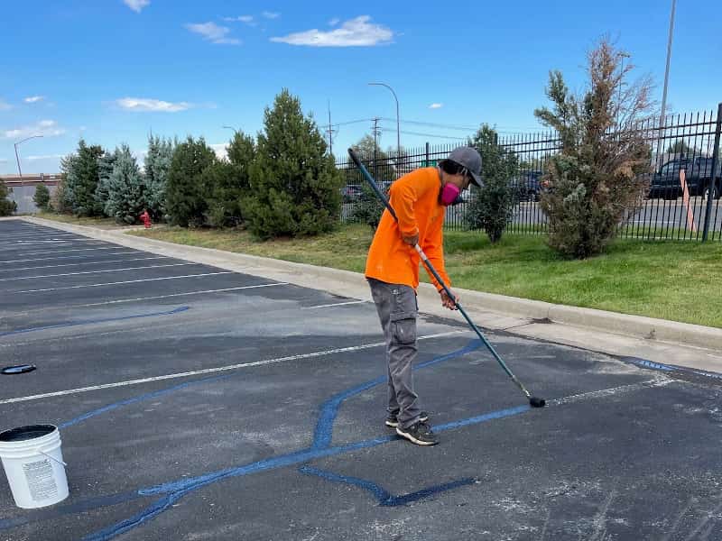 Cracks in asphalt being sealed with hot rubber