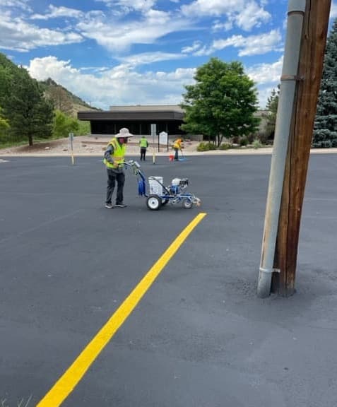 worker painting new parking stall lines