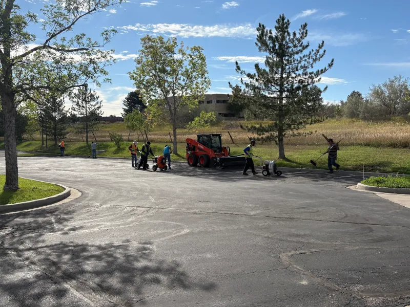 crew cleaning parking lot before sealcoating